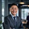 佐山爱创始人李维，西装革履面带自信微笑，在现代化办公室内接受采访，展现出成熟稳重的领导气质